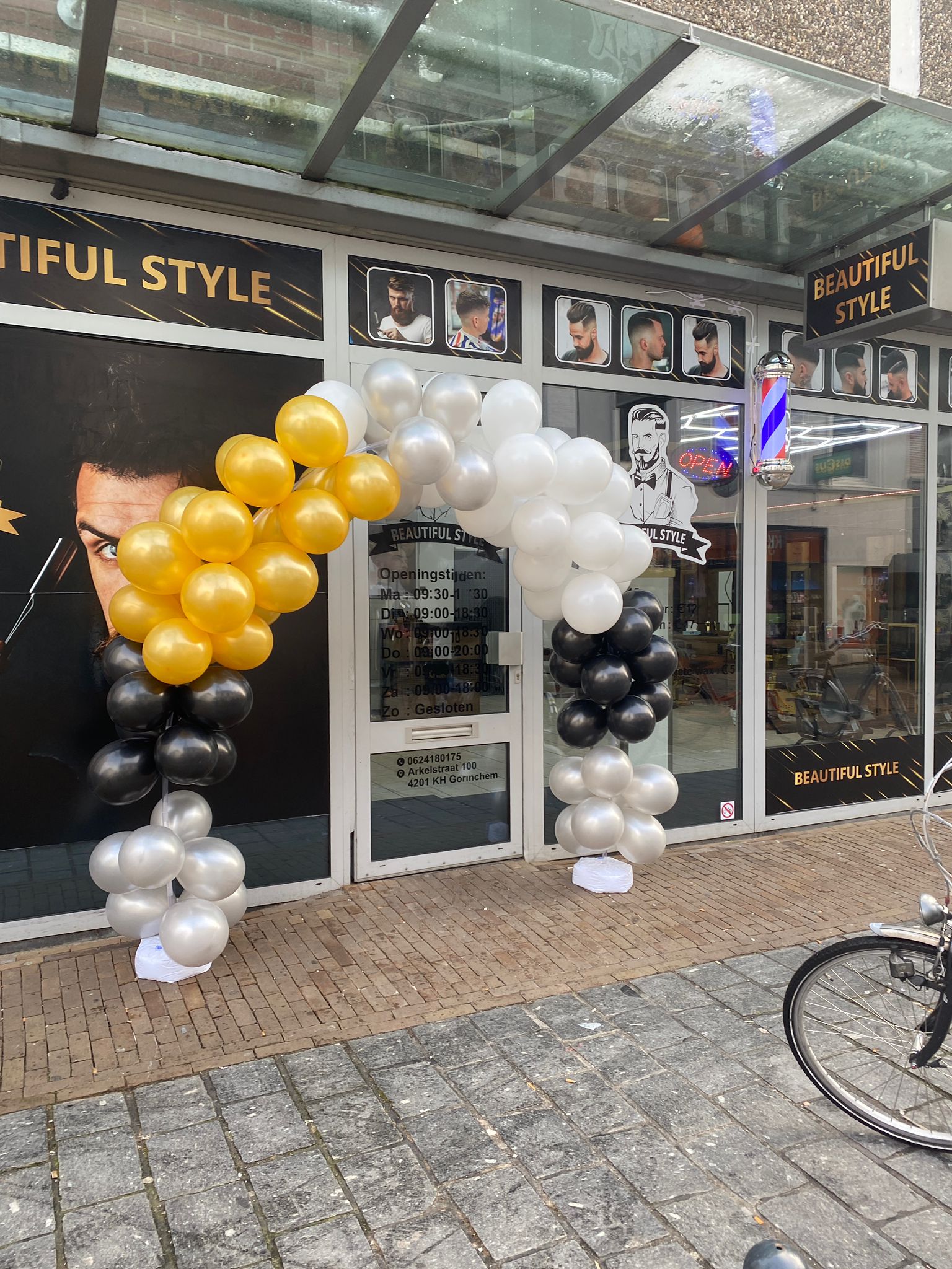 De ingang van Beautiful Style met een ballonnenboog in zwart, wit en goud bij de opening