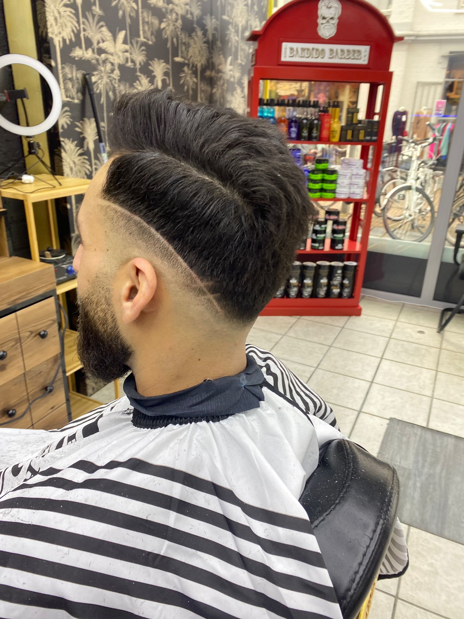 Strakke skin fade met scheidingslijn en verzorgde baard, geknipt bij Beautiful Style